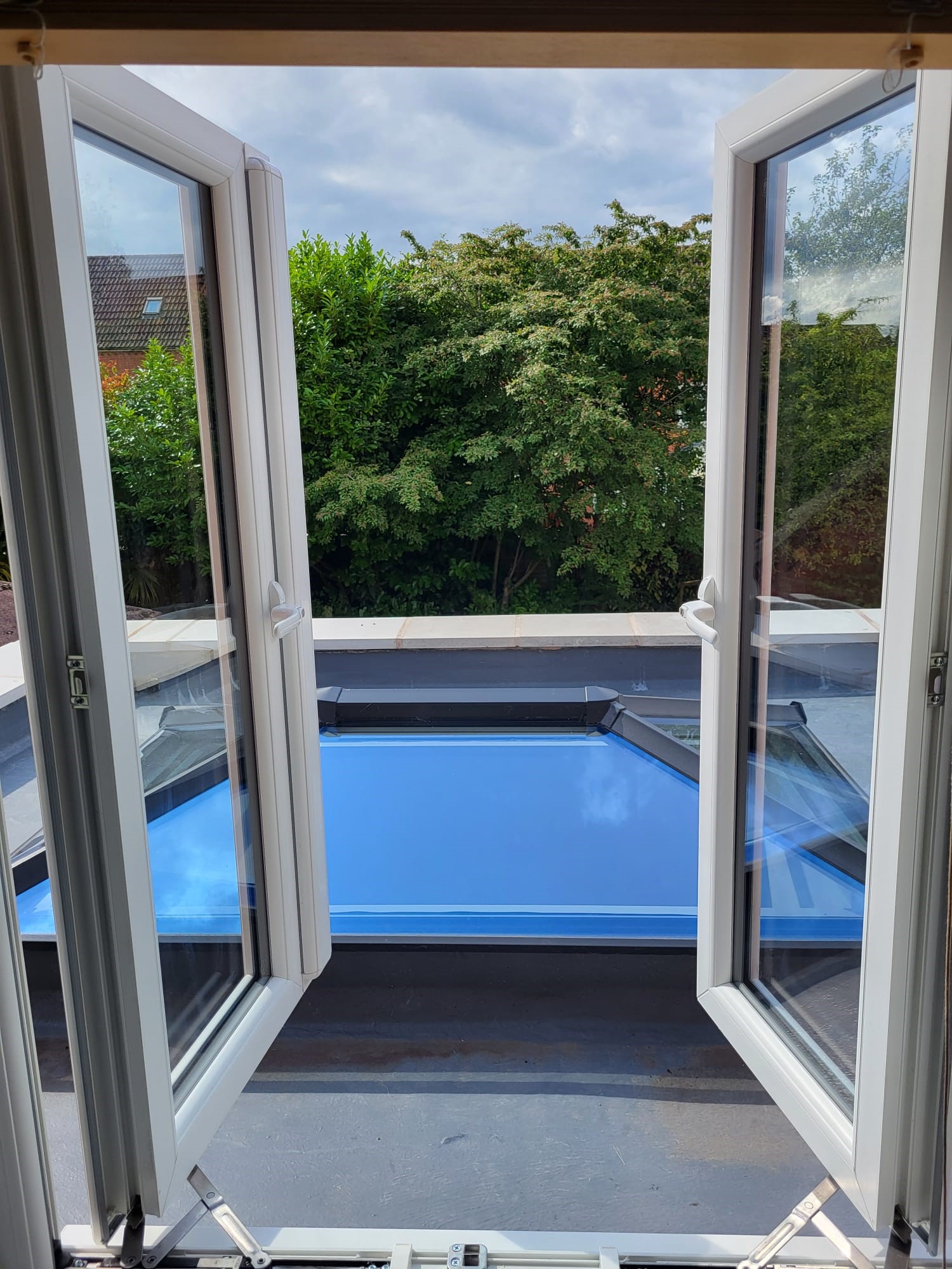UPVC windows open to a tree and roof